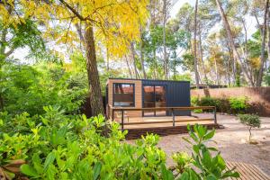 a tiny house sitting in the middle of a garden at Cabañas del bosque Sacedón in Sacedón
