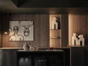 a room with a table with vases and paintings at NAUMA PAROS Design Boutique Hotel in Naousa