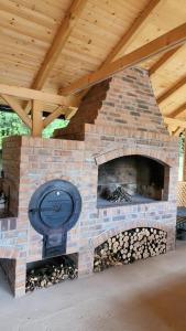 an outdoor brick oven with a wooden roof at Bella House in Sarajevo