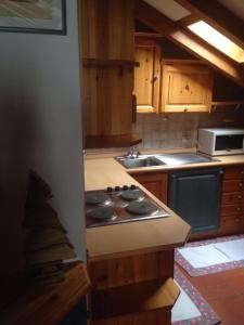 uma cozinha com um fogão e um lavatório em Villa San Martino em San Martino di Castrozza