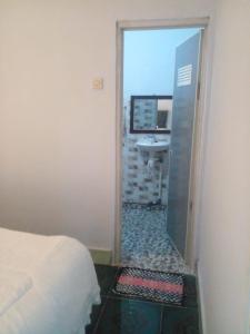 a bedroom with a bed and a bathroom with a sink at Hans Surfer Homestay in Bumbang