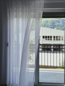 a window with white curtains and a view of a building at Guest House 369 in Jajce +9 photos