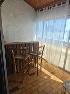 une table et des chaises dans une pièce avec une fenêtre dans l'établissement L'anse duRhône, à Port-Saint-Louis-du-Rhône