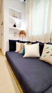 a blue couch with white pillows in a room at Dar Houta Hammamet Mrezga in Nabeul
