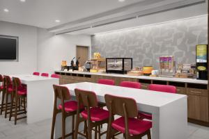 哥伦布Home2 Suites By Hilton Columbus Easton的有桌椅和柜台的餐厅