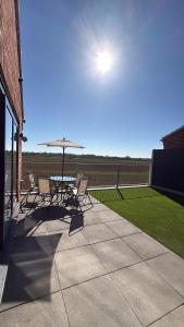 a patio with chairs and a table and an umbrella at California Fields 2 Brand new open may in Scratby +38 photos