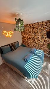a bed in a room with a wall of logs at California Fields 2 Brand new open may in Scratby