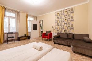 a large room with a bed and a couch and a tv at EcoStay Apartment by the Basilica in Budapest