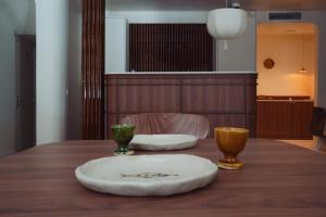 een houten tafel met twee borden en twee kopjes erop bij LALA Hôtel in Parijs