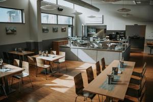 a restaurant with wooden tables and chairs and a counter at Campus Bad Kissingen in Bad Kissingen