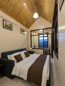 a bedroom with a large bed and a window at The Mall Ethos - On Mall Road - Kitchen - Sleeps 4 in Shimla