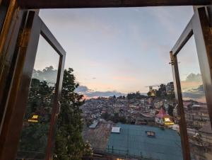 a view of a city from a window at The Mall Ethos - On Mall Road - Kitchen - Sleeps 4 in Shimla