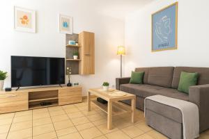 Una sala de estar con un sofá y un televisor de pantalla plana. en BALTIQ Apartments, en Ustka