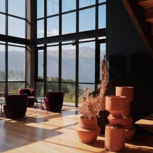 a room with windows and potted plants with mountains in the background at Samzeo Tusheti in Omalo