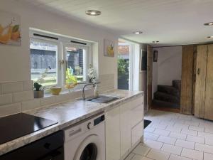 a kitchen with a sink and a washing machine at Jasmine Cottage in Burgh le Marsh