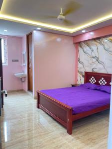 a bedroom with a purple bed in a room at Yellow Bliss Homestay in Coimbatore