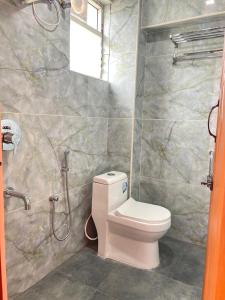 a bathroom with a toilet and a shower at Yellow Bliss Homestay in Coimbatore