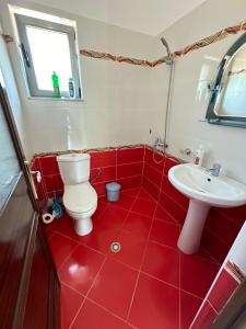 a red bathroom with a toilet and a sink at Esmeralda Hotel & Restaurant in Ksamil +88 photos