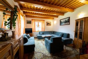 a living room with blue couches and a tv at Penzion HACIENDA in Liptovská Osada