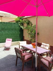 una mesa con una sombrilla rosa en el patio en Casa abuela Gaspara I, en Villalcázar de Sirga