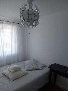 a white bedroom with a bed with a chandelier at SaFaRi 19 