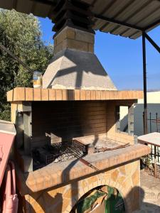an outdoor brick oven with a roof at Esmeralda Hotel & Restaurant in Ksamil