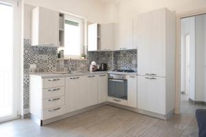 een witte keuken met witte kasten en een raam bij B&B Monteleone ,12 in Napels