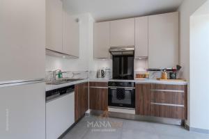 a kitchen with white cabinets and a stove top oven at La Villa Tahaa, 6/8 pers, 10 Disneyland Paris in Chanteloup-en-Brie +39 photos