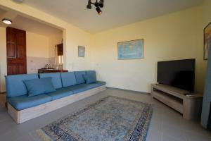 シャーラにある3 Bdr Apt with Panoramic Valley Beach Viewsの青いソファと薄型テレビのあるリビングルーム