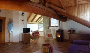 a living room with wooden ceilings and a dining room at Appartamenti Grivola in Ozein