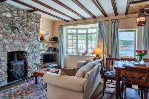 a living room with a stone fireplace and a couch at Finest Retreats - April Cottage in Cawsand