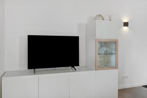 a flat screen tv sitting on top of a white entertainment center at Ferienwohnung Seeglück in Moos +19 photos
