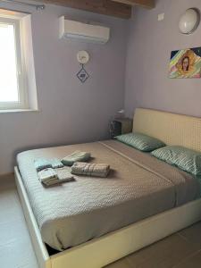 a bed in a room with two towels on it at La Stanzetta Viola in Fezzano