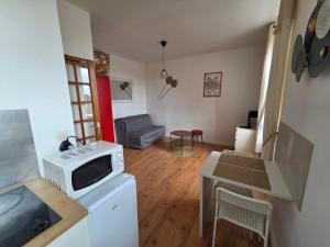 a small living room with a microwave and a table at Studio la république in Tréguier