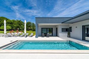 a swimming pool in front of a house at Villa Valinka Design in Golaš