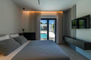 a bedroom with a bed and a tv and a pool at Villa Valinka Design in Golaš +35 photos