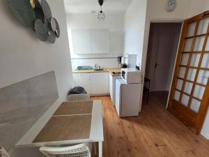 a kitchen with a table and a white refrigerator at Studio la république in Tréguier
