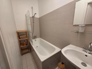 a bathroom with a sink and a bath tub next to a toilet at Studio la république in Tréguier