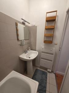a white bathroom with a sink and a toilet at Studio la république in Tréguier