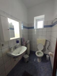 a bathroom with a toilet and a sink at Trifyllianika Calm View in Trifilliánika