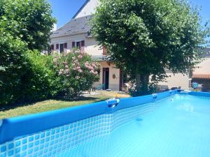 a blue swimming pool in front of a house at Maison de maître in Argelès-Gazost