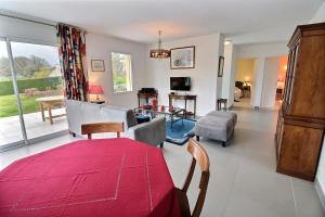 a living room with a red blanket on a table at Les jardins de kerarzic in Ploubazlanec