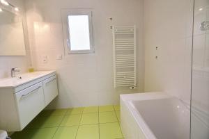 a white bathroom with a tub and a sink at Les jardins de kerarzic in Ploubazlanec +15 photos