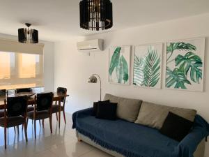 a living room with a blue couch and a table at ALOHA Güemes Premium, 2 dorm con Vista a las Sierras in Córdoba