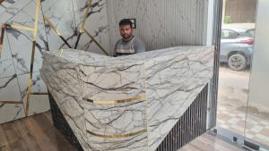 a man is standing behind a marble wall at The Rabbit Hotel in Bareilly