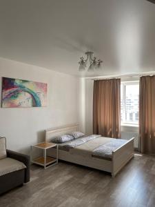a bedroom with a bed and a couch and a window at Однокімнатна квартира в центрі, на вулиці Набережна,10 з парковкою in Luts'k