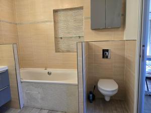 a bathroom with a tub and a toilet and a sink at Appartement avec jardin 4 personnes in Fréjus