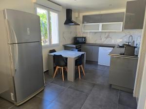 a kitchen with a refrigerator and a table and chairs at Appartement avec jardin 4 personnes in Fréjus