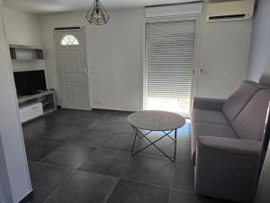 a living room with a couch and a table at Appartement avec jardin 4 personnes in Fréjus