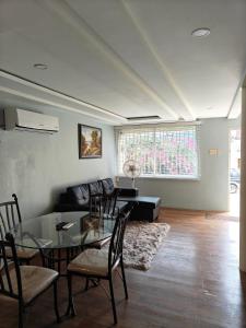 a living room with a glass table and a couch at The Cozy Flat by UWI in Hope Pastures